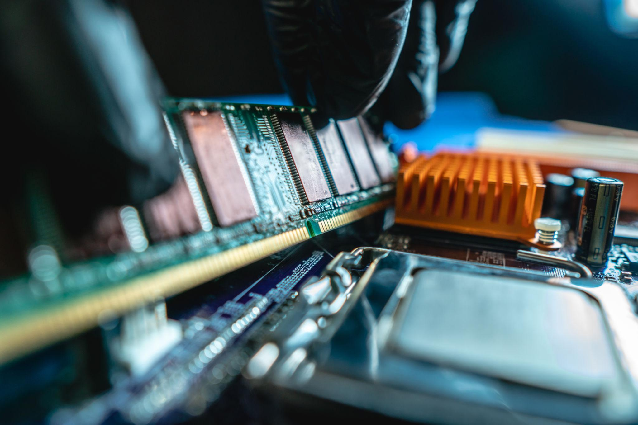Close-up of RAM being installed onto a motherboard during a hardware upgrade